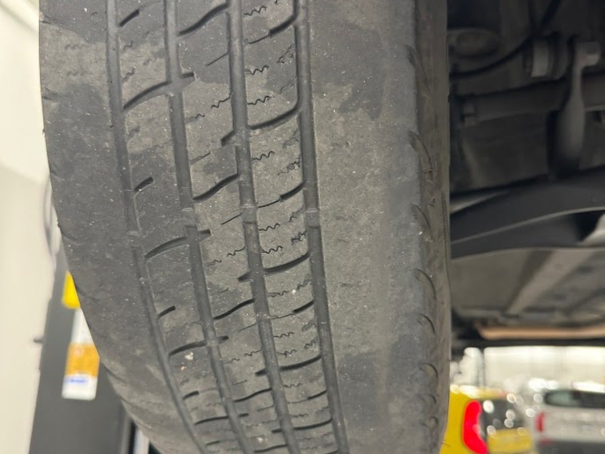 Uneven tire tread wear that may indicate a wheel alignment concern at Kia of Portland