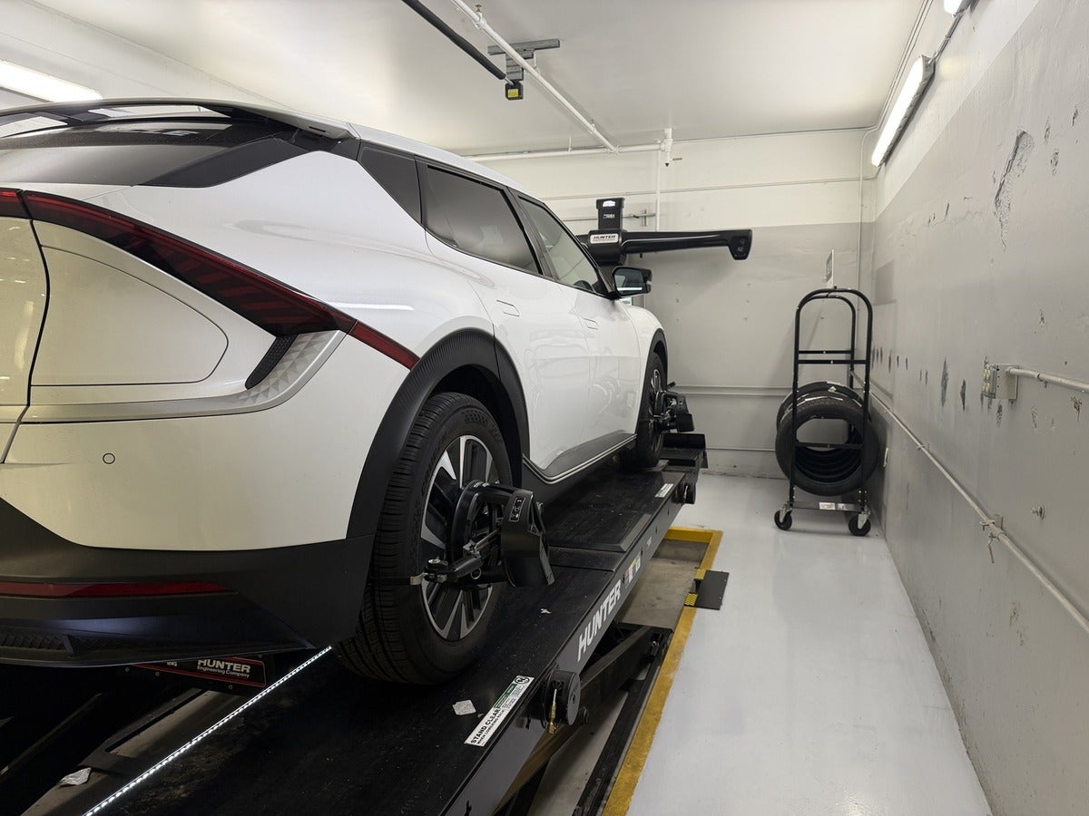 Kia EV6 positioned on a Hunter wheel alignment rack at Kia of Portland