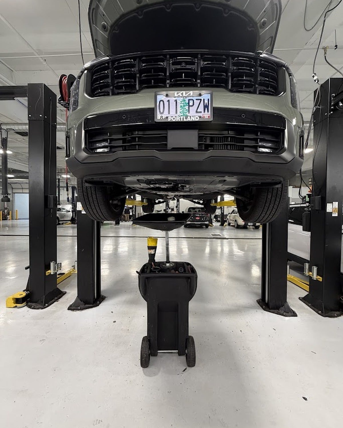 Kia positioned on a service lift for an oil change at Kia of Portland